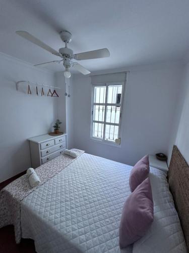 a white bedroom with a bed and a window at La escalera in Zahara de la Sierra