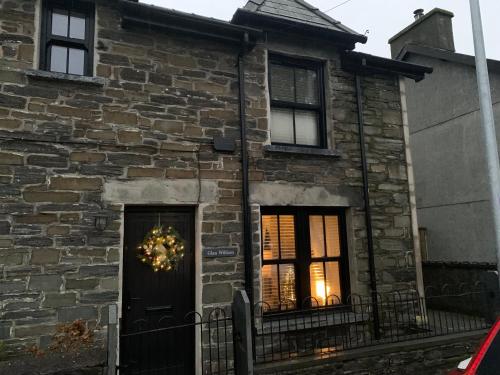 a brick house with a christmas wreath on the door at Glan William in Dolwyddelan