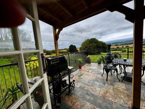 a view of a patio with a grill and a table at Burtree Country House, Tipi's, Treehouse & Lodge & house rooms with hot tubs in a private garden in Thirsk