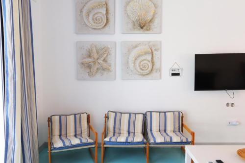 two chairs in a room with a tv and pictures on the wall at PH in Aroeira Lisbon - Beach & Golf in Aroeira
