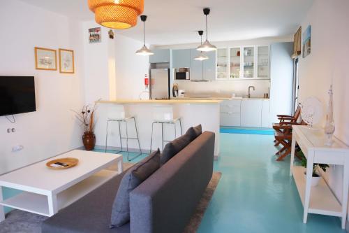 a living room with a couch and a kitchen at PH in Aroeira Lisbon - Beach & Golf in Aroeira