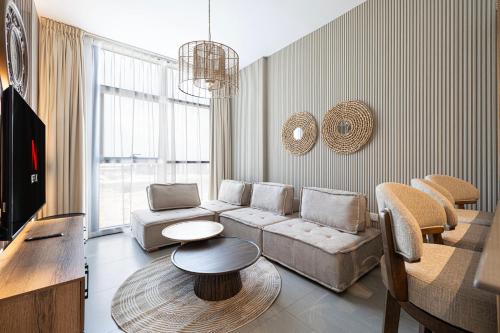 a living room with a couch and a table at 1BHK Sharjah Luxury Apartment - Designer Den in Sharjah Intl