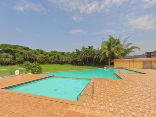卡尔贾特Ivy Bliss Studio with Private Pool, B 06, Karjat的棕榈树度假村内的大型游泳池