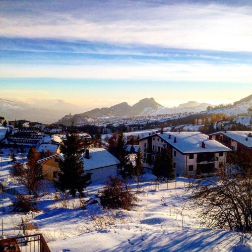 a town covered in snow with mountains in the background at La baita di Marianna in Gamberale