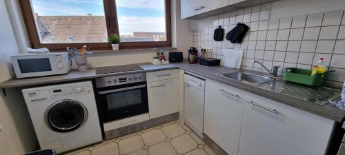a kitchen with a washing machine and a sink at Fine Living - Zentral nahe A2 mit Parkplatz Küche Arbeitsplatz in Peine
