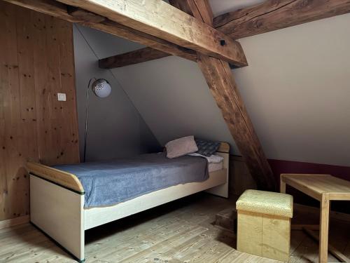 Ce petit lit se trouve dans un dortoir doté de plafonds en bois. dans l'établissement Beau duplex proche centre, à Kaysersberg