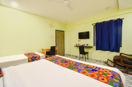 a hotel room with two beds and a table and chairs at FabHotel Galaxy Shamshabed - Nr Hyderabad International Airport, Shamshabad in Shamshabad
