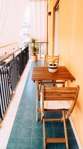 a balcony with a wooden table and chairs at Donna Concetta seaside apartment in Giardini Naxos