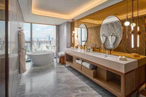 a bathroom with a tub and a sink and mirror at InterContinental Taichung by IHG in Taichung