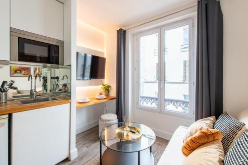 un salon avec un canapé et une table dans l'établissement Cozy Studio - Eiffel Tower - Sleeps 2P, à Paris