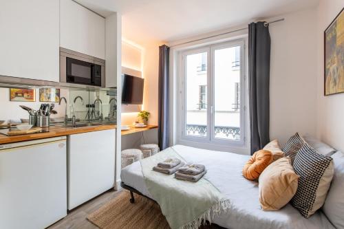 une petite chambre avec un lit et une cuisine dans l'établissement Cozy Studio - Eiffel Tower - Sleeps 2P, à Paris