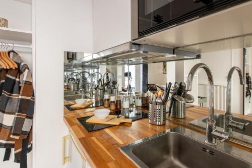 d'une cuisine équipée d'appareils en acier inoxydable et d'un évier. dans l'établissement Cozy Studio - Eiffel Tower - Sleeps 2P, à Paris