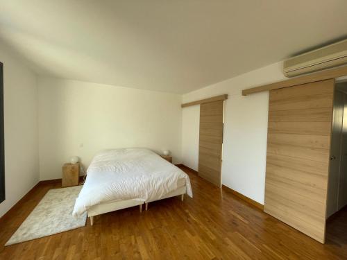 - une chambre avec un lit blanc et du parquet dans l'établissement Villa contemporaine et minimaliste, aux Angles (Gard)