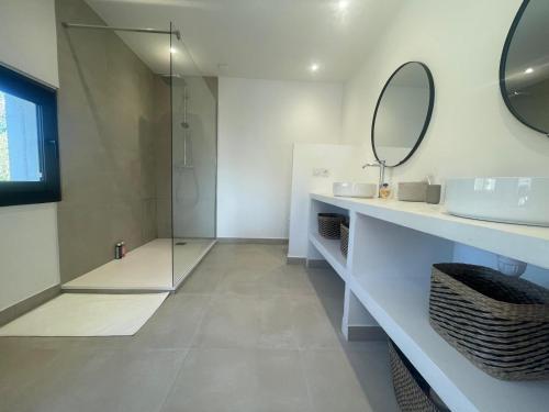 une salle de bain avec une douche, un lavabo et un miroir dans l'établissement Villa contemporaine et minimaliste, aux Angles (Gard)