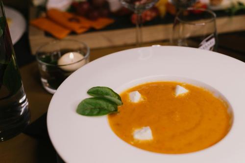 a white plate with a bowl of soup on a table at Economy Silesian Hotel in Katowice