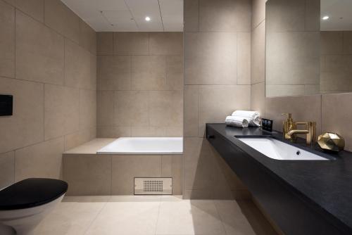 uma casa de banho com uma banheira, um WC e um lavatório. em Clarion Hotel Air em Sola