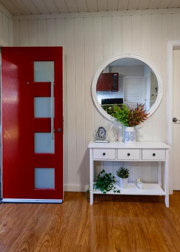 a room with a red door and a table with a mirror at home in capelsound in Capel Sound