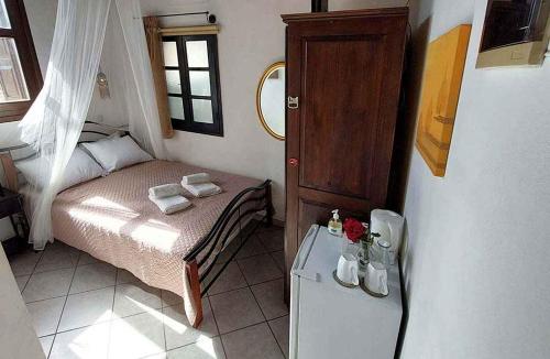a small bedroom with a bed and a refrigerator at Saint Michel Hotel in Rhodes Town