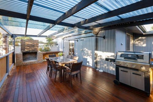 a kitchen with a table and a stove on a deck at home in capelsound in Capel Sound