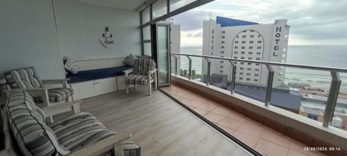a balcony with chairs and a view of the ocean at Vista Bonita Apartments in Mossel Bay