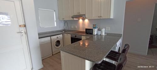 a kitchen with a counter with a sink and a stove at Vista Bonita Apartments in Mossel Bay