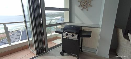 a desk in a room with a view of the ocean at Vista Bonita Apartments in Mossel Bay