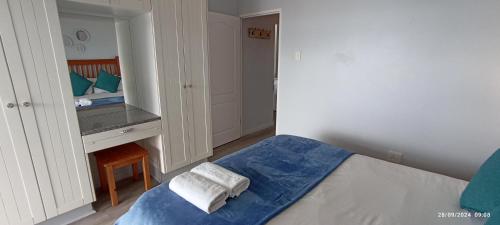 a small bedroom with a bed and a desk at Vista Bonita Apartments in Mossel Bay