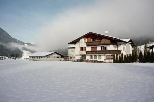 a snow covered field in front of a house at Schernhof in Söll