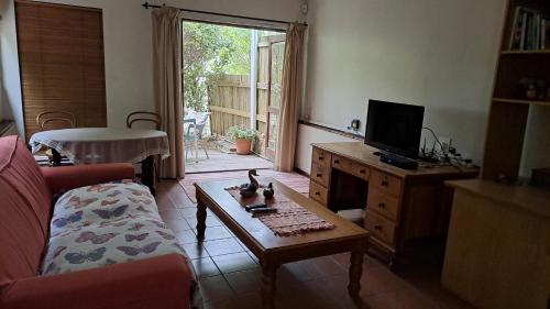 a living room with a couch and a table at Martha's Place in Gordonʼs Bay