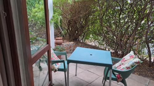 a blue table and two chairs on a porch at Martha's Place in Gordonʼs Bay