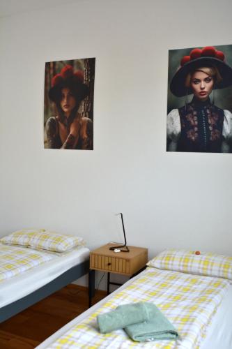 a bedroom with two beds and a painting of a woman at Schwarzwald Lahr Europapark Penthouse Sunshine in Lahr
