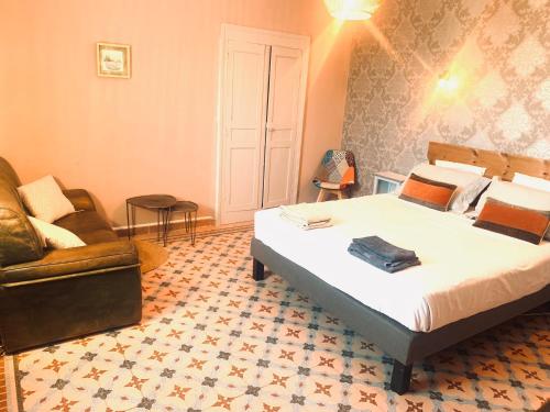 une chambre d'hôtel avec un lit et un canapé dans l'établissement Les Volets Rouges, à Saint-Sauveur-de-Cruzières