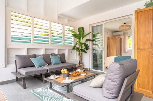 a living room with a couch and a table at Villa Opale in Terre-de-Haut