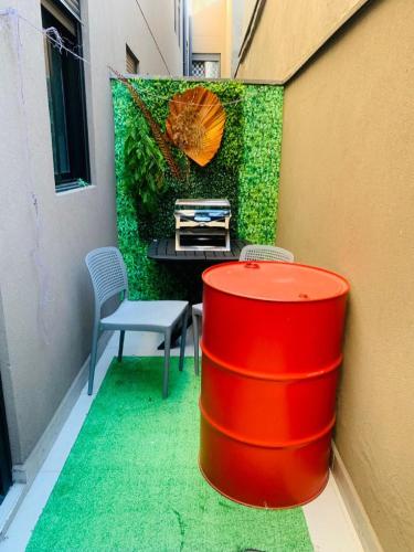 a red barrel sitting next to a table and chairs at Loft Moderno com Ar Condicionado, Estacionamento Gratuito & Wi-Fi Brás, Expo Center Norte e Anhembi in Sao Paulo