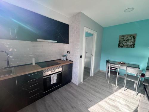 a kitchen with a sink and a table with chairs at Vistas Sobia San Martín de teverga in San Martín