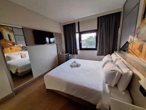 a hotel room with a large bed and a mirror at B&B Hotel Udine in Udine