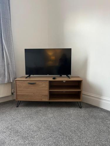 a flat screen tv sitting on top of a wooden entertainment center at Alston House in Hartlepool
