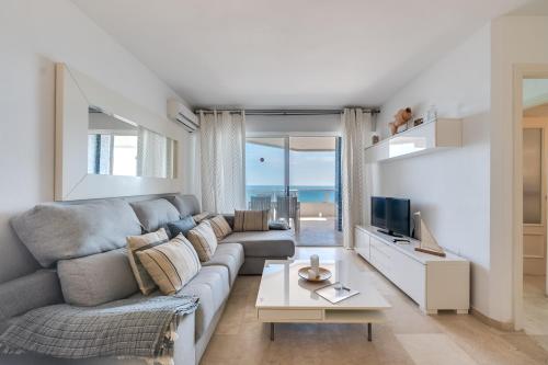 salon z kanapą i telewizorem w obiekcie LXR La Carihuela Sea Views 3HAB w mieście Torremolinos