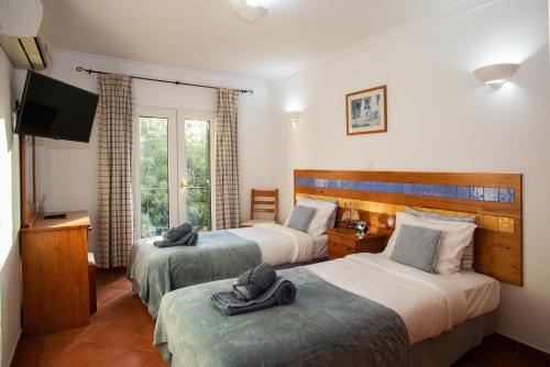 a hotel room with two beds and a flat screen tv at Casa das Marés by east ALgarve guest in Tavira