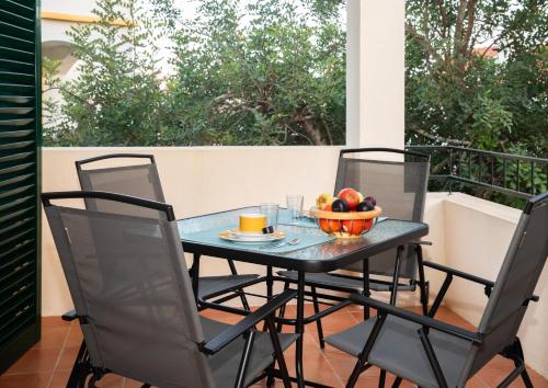 a table and chairs on a balcony with a bowl of fruit at Casa das Marés by east ALgarve guest in Tavira
