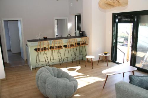 a living room with a kitchen and a bar with stools at Katakolo 2 Bedroom Apartment by MPS in Katakolon