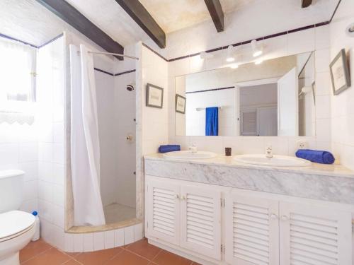 un bagno con due lavandini, una doccia e un WC di Villa Es Cantell a Binisafua