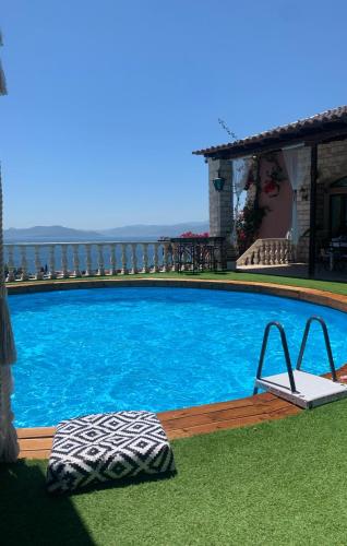 a large blue swimming pool with a chair in the grass at Eva's Luxury Villa in Kritharia