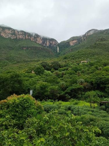 a lush green hillside with trees and mountains at Chale1 RabodeGalo in Santana do Riacho