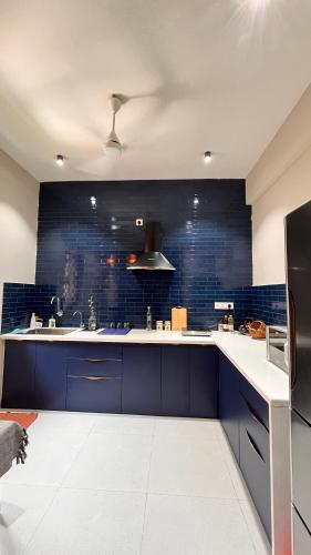 a large kitchen with blue tiles on the wall at Casa Juno in Aguada