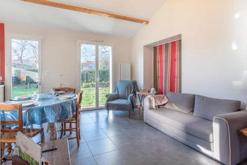 un salon avec un canapé et une table dans l'établissement Petite maison à la campagne, à Saint-Georges-de-Pointindoux