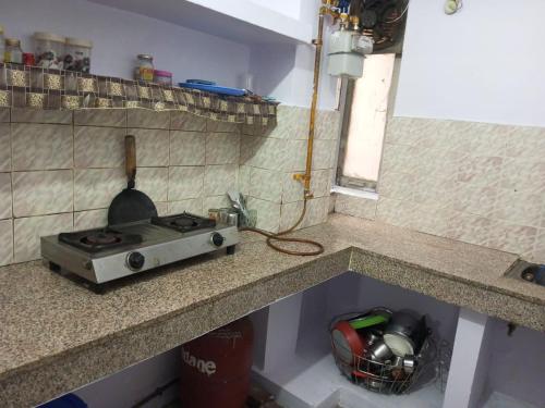 a kitchen counter with a stove in the corner at New Dev Homestay in Prayagraj