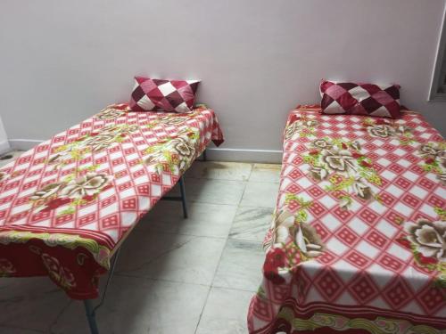 two beds sitting next to each other in a room at New Dev Homestay in Prayagraj