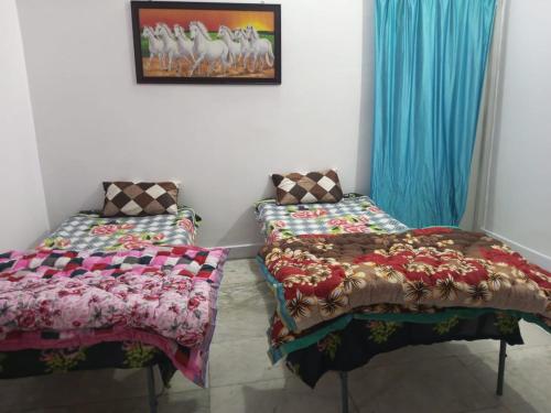 two beds sitting next to each other in a room at New Dev Homestay in Prayagraj
