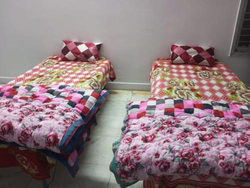 two beds sitting next to each other in a room at New Dev Homestay in Prayagraj